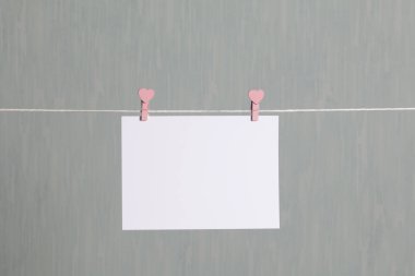 Fotoğrafik baskılar sonra gelişmekte olan bir kablosunun üzerine ve kuru sıkı. İçerik eklemek için bir yer vardır. Giyim mandal farklı pozisyonlarda kablosuyla bağlı. Bir gri-yeşil arka plan üzerinde.