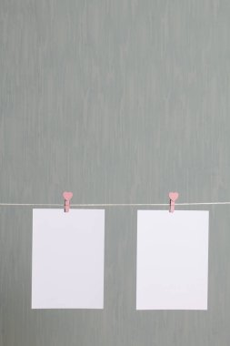 Fotoğrafik baskılar sonra gelişmekte olan bir kablosunun üzerine ve kuru sıkı. İçerik eklemek için bir yer vardır. Giyim mandal farklı pozisyonlarda kablosuyla bağlı. Bir gri-yeşil arka plan üzerinde.