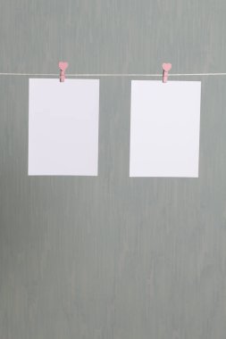 Fotoğrafik baskılar sonra gelişmekte olan bir kablosunun üzerine ve kuru sıkı. İçerik eklemek için bir yer vardır. Giyim mandal farklı pozisyonlarda kablosuyla bağlı. Bir gri-yeşil arka plan üzerinde.