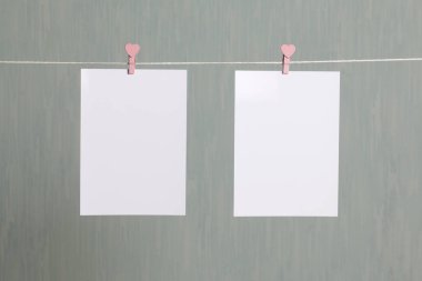 Fotoğrafik baskılar sonra gelişmekte olan bir kablosunun üzerine ve kuru sıkı. İçerik eklemek için bir yer vardır. Giyim mandal farklı pozisyonlarda kablosuyla bağlı. Bir gri-yeşil arka plan üzerinde.