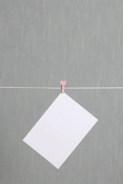 Fotoğrafik baskılar sonra gelişmekte olan bir kablosunun üzerine ve kuru sıkı. İçerik eklemek için bir yer vardır. Giyim mandal farklı pozisyonlarda kablosuyla bağlı. Bir gri-yeşil arka plan üzerinde.