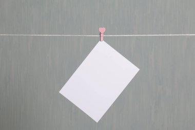 Fotoğrafik baskılar sonra gelişmekte olan bir kablosunun üzerine ve kuru sıkı. İçerik eklemek için bir yer vardır. Giyim mandal farklı pozisyonlarda kablosuyla bağlı. Bir gri-yeşil arka plan üzerinde.