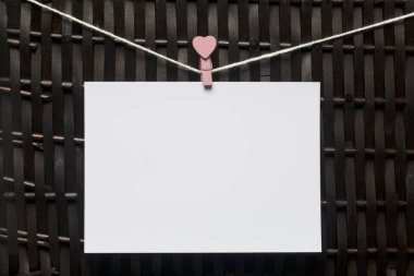 Fotoğrafik baskılar sonra gelişmekte olan bir kablosunun üzerine ve kuru sıkı. İçerik eklemek için bir yer vardır. Giyim mandal farklı pozisyonlarda kablosuyla bağlı. Bir kahverengi Hasır arka plan üzerinde.