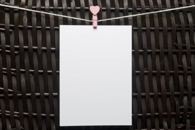 Fotoğrafik baskılar sonra gelişmekte olan bir kablosunun üzerine ve kuru sıkı. İçerik eklemek için bir yer vardır. Giyim mandal farklı pozisyonlarda kablosuyla bağlı. Bir kahverengi Hasır arka plan üzerinde.