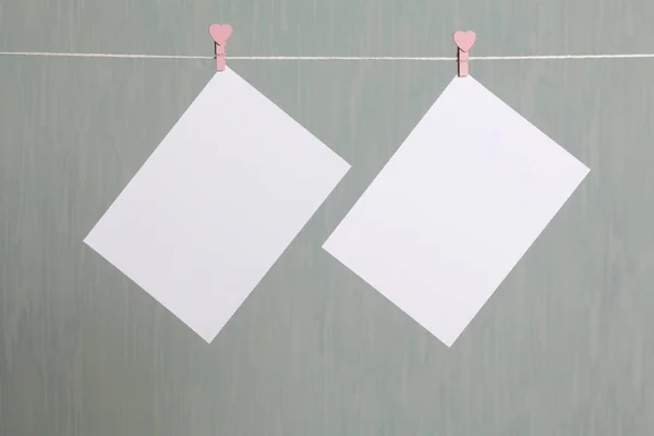 Fotografische afdrukken hangen na het ontwikkelen van op een koord en droog. Er is een plek om uw inhoud invoegen. Gekoppeld aan het koord met wasknijpers in verschillende posities. Op een grijs-groene achtergrond. — Stockfoto