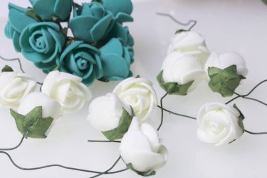 Kutlamalar için süsler. Altın yüzük taşlar ve yapay çiçekler buket. Gül bej ve Zümrüt renklerdir. Beyaz bir arka plan üzerinde.