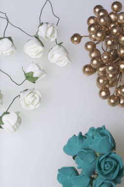 Kutlamalar için süsler. Altın yüzük taşlar ve yapay çiçekler buket. Gül bej ve Zümrüt renklerdir. Beyaz bir arka plan üzerinde.