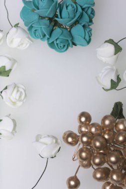 Kutlamalar için süsler. Altın yüzük taşlar ve yapay çiçekler buket. Gül bej ve Zümrüt renklerdir. Beyaz bir arka plan üzerinde.