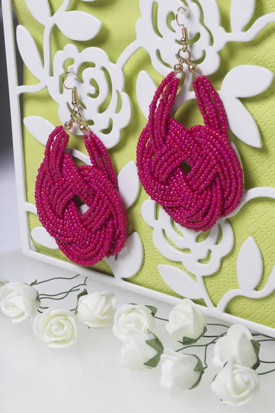 女性的珊瑚色的耳环。手工制作的珠子。人工玫瑰是米色的装饰. — 图库照片