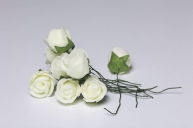 Kutlamalar için süsler. Yapay çiçek bir buket. Gül beyaz bir arka plan üzerinde bej.