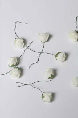 Kutlamalar için süsler. Yapay çiçek bir buket. Gül beyaz bir arka plan üzerinde bej.
