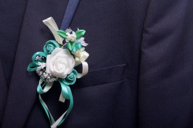 Damat'ın takım elbise bir askı üzerinde asılı. Göğsüne bağlı bir düğün çiçek.