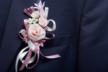 Damat'ın takım elbise bir askı üzerinde asılı. Göğsüne bağlı bir düğün çiçek.