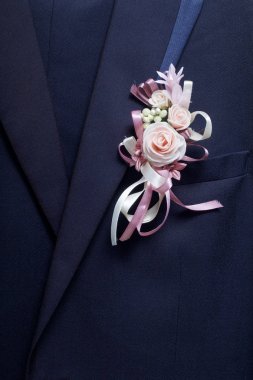 Damat'ın takım elbise bir askı üzerinde asılı. Göğsüne bağlı bir düğün çiçek.