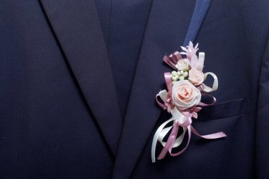 Damat'ın takım elbise bir askı üzerinde asılı. Göğsüne bağlı bir düğün çiçek.