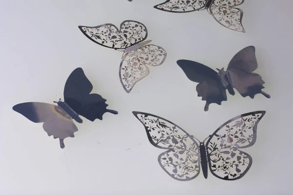 On the white surface lie decorations made of butterflies cut from foil. — Stock Photo, Image