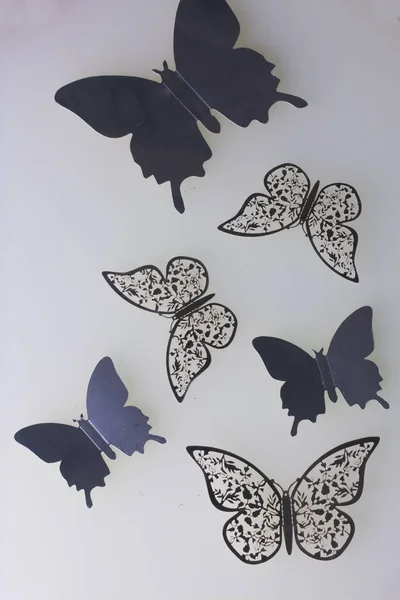 На білій поверхні лежать прикраси з метеликів, вирізаних з фольги . — стокове фото