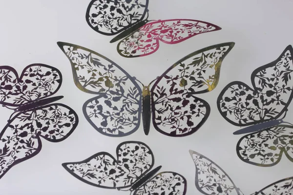 Sulla superficie bianca si trovano decorazioni fatte di farfalle tagliate da lamina . — Foto Stock