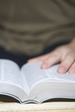 Genç bir adam panoları ahşap bir tahta üzerinde döşeme İncil okur.