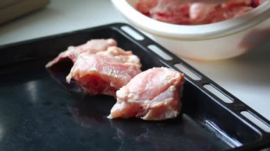 Adam bir fırın tepsisine tavuk parçaları koyar. İçinde mayonez Marine et.