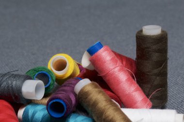 Arka plan iş parçacığı üzerinde gri bir farklı renkteki bobinleri dokuma