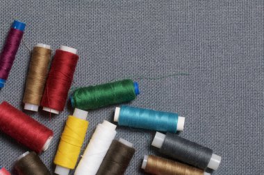 Arka plan iş parçacığı üzerinde gri bir farklı renkteki bobinleri dokuma