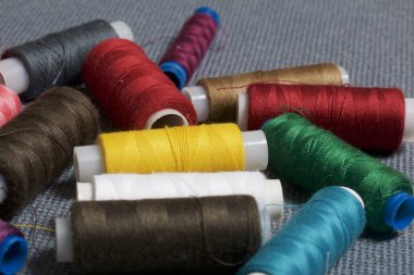 Arka plan iş parçacığı üzerinde gri bir farklı renkteki bobinleri dokuma