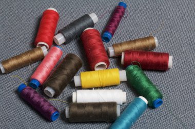 Arka plan iş parçacığı üzerinde gri bir farklı renkteki bobinleri dokuma