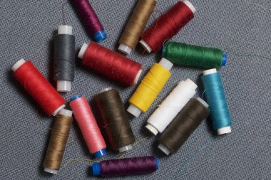 Arka plan iş parçacığı üzerinde gri bir farklı renkteki bobinleri dokuma