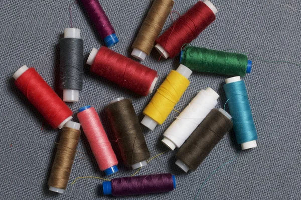 Arka plan iş parçacığı üzerinde gri bir farklı renkteki bobinleri dokuma