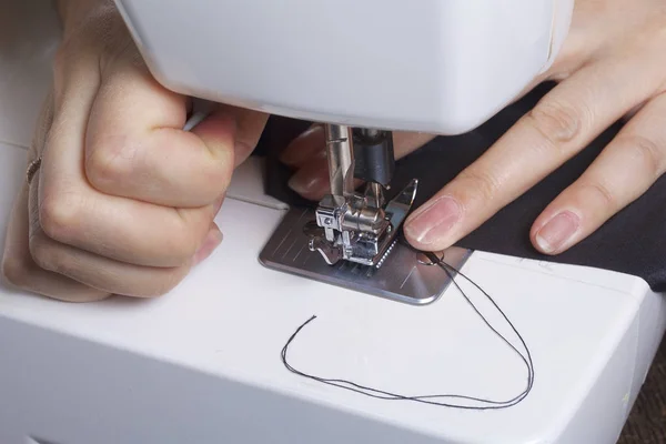 Costura de ropa por un empresario individual. Una mujer está trabajando en una máquina de coser. Grapas los elementos cortados del producto . —  Fotos de Stock