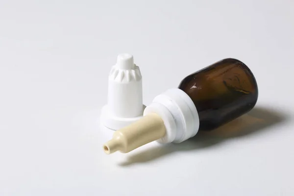 Nasal spray. De flacon met het medicijn, met het GLB verwijderd, berust op het witte oppervlak van de tabel. — Stockfoto