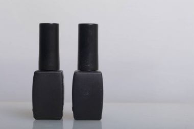 Kaplama ile jel-vernik çivi. Beyaz bir yüzeye jel-Lake siyah şişe standları.