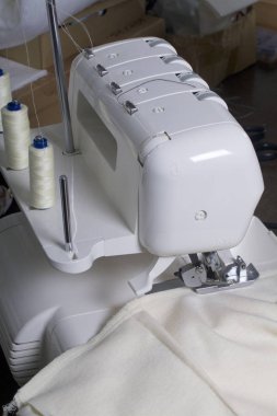 Overlok üzerinde işleme ürün. Yüklü beyaz konu ve overlok kelepçe içinde klempe kumaş ile overlok.