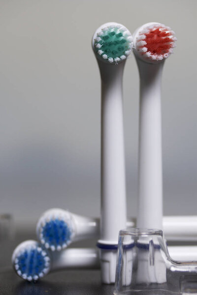 Nozzles for electric toothbrush. Lie on a dark surface. On a white background.