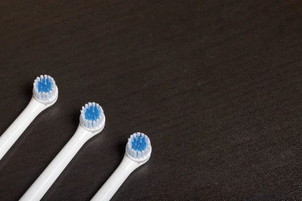 Nozzles for electric toothbrush. Lie on a dark surface. — Stock Photo, Image
