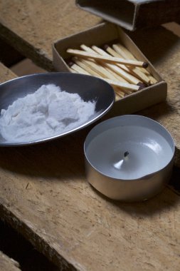 Uyuşturucu salgını. Yemek pişirmek için uyuşturucu içine bir kaşık dökülür. Bu bir ahşap kutu üzerinde yatıyor. Sonraki mum ve maçlar.