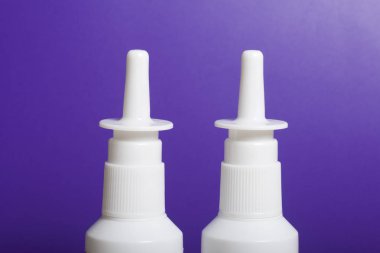 Burun spreyi yüzeyde hazır. Lila bir arka plan üzerinde.