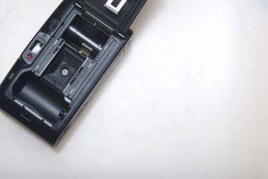 Eski yarı otomatik fotoğraf makinesi. Açık bir arka kapak ile. Beyaz bir yüzeye yatıyor. Yukarıdan görüntülemek.