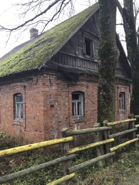 Eski terk edilmiş bir evde kırmızı tuğla yaptı. Camları kırık, yosun ve liken ile büyümüş çatıda eski kayrak.