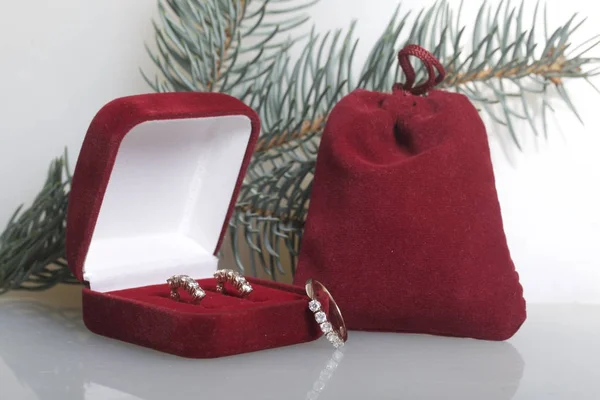 Egy ajándék egy szeretett. A piros bársony tok és egy ajándék doboz. A közelben van egy arany gyűrű. A fehér háttér, a fenyő ága. — Stock Fotó