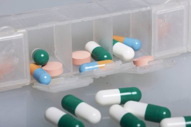 Devrilmiş tablet ilaç ile. Masada çok renkli Tablet ve hapları dağılmış. Beyaz bir arka plan üzerinde.