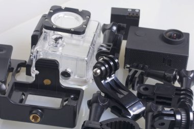 Eylem kamerayı beyaz bir yüzeye yatıyor. Eylem kamerayı beyaz bir yüzeye yatıyor. Sualtı çekim için kutusu yedek pil ve diğer aksesuarları. Yukarıdan görüntülemek.