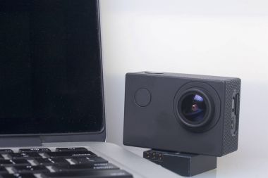 Eylem kamera pil dizüstü yanında açık mı. Beyaz bir arka plan üzerinde.