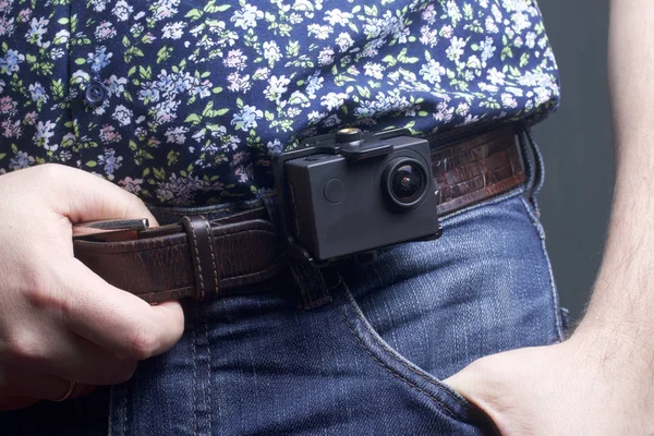 The action camera is fixed to the waist belt of a man.