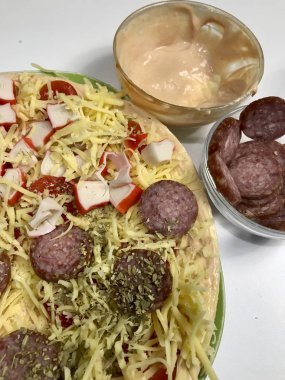 Pizza hazırlık. Gerekli malzemeler olarak konur: peynir, sosis ve sebze.