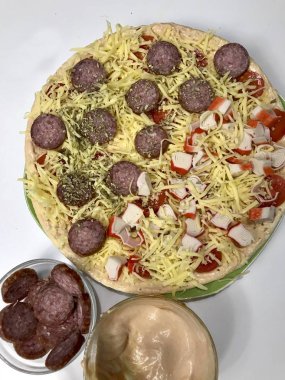 Pizza hazırlık. Gerekli malzemeler olarak konur: peynir, sosis ve sebze.