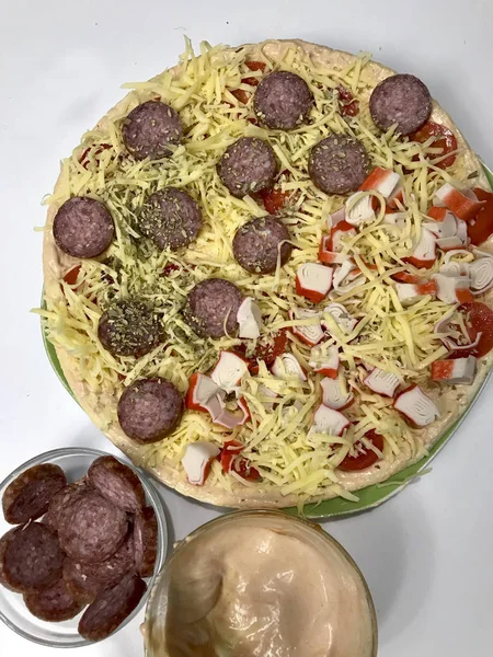 Pizza hazırlık. Gerekli malzemeler olarak konur: peynir, sosis ve sebze.