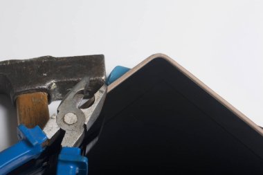 Tablet ve çalışma araçları. Beyaz tablo üzerinde bir tablet, skein, keski ve pense yüzeydir. Yıkım ve elektronik cihazların tamiri.