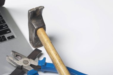 Dizüstü bilgisayar ve çalışma araçları. Beyaz tablo üzerinde bir tablet, skein, keski ve pense yüzeydir. Yıkım ve elektronik cihazların tamiri.